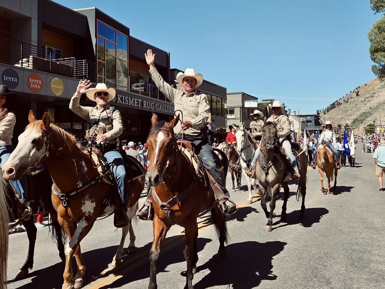 Sheriff Matt Carr riding on horseback and waving to the crowd during a parade in downtown Jackson